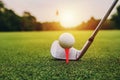 closeup golf club and golf ball on green grass wiht sunset Royalty Free Stock Photo