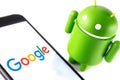 Google Android figure and smartphone with Google logo