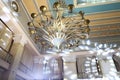 Closeup of gorgeous gold metal chandelier with stars and ears of wheat. Palace ceiling with beautiful lighting