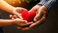 Hands of an Elderly Man and a Child Holding a Red Heart - Generative Ai Royalty Free Stock Photo