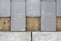 Closeup of gray concrete paving bricks with exposed earth in patterned layout Royalty Free Stock Photo