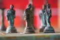 Closeup of Greek mythology chess pieces on the board with a red blurry background