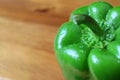 Closeup a Green bell pepper with water droplets isolated on the wooden background Royalty Free Stock Photo