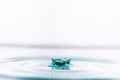 Closeup of green colored water drop splashing in clear water. Royalty Free Stock Photo