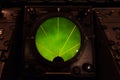 Closeup of green glowing aircraft radar gauge display.