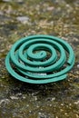 closeup the green mosquito coil hold with metal stand soft focus natural green brown background