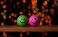 Closeup of green and pink smiley balls with bokeh lights blurred background