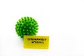 Closeup on green spiky ball as coronavirus representation and post-it note with Coronavirus Updates handwritten message isolated