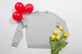 Closeup grey blank template sweatshirt hoodie copy space. Mothers women day yellow tulips, air balloons. Happy birthday top view Royalty Free Stock Photo