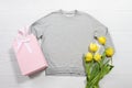 Closeup grey blank template sweatshirt hoodie copy space. Mothers women day yellow tulips, gifts. Happy birthday top view mockup Royalty Free Stock Photo