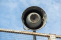 A closeup of a grey loudspeaker hanging from a metal net Royalty Free Stock Photo