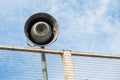 A closeup of a grey loudspeaker hanging from a metal net Royalty Free Stock Photo