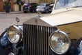 Closeup of the grille, logo and headlights on a classic antique vintage Rolls Royce car.