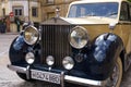 Closeup of the grille, logo and headlights on a classic antique vintage Rolls Royce car.