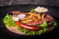 Closeup of grilled sausages with french fries, ketchup and side salad decorated with lettuce Royalty Free Stock Photo