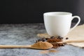 Closeup ground coffee in wooden spoon and fresh roasted coffee beans with a cup of hot coffee. Royalty Free Stock Photo