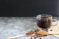 Closeup ground coffee in wooden spoon and fresh roasted coffee beans with a cup. Royalty Free Stock Photo