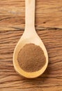 Closeup of ground cumin on a spoon over wooden table Royalty Free Stock Photo