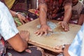 Closeup of group of balinese men playing cards on the floor. Bali island, Indonesia.