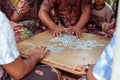 Closeup of group of balinese men playing cards on the floor. Bali island, Indonesia.