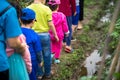 Closeup group of children walking on cultivation land field to learn to farming.