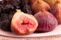 Closeup of group of figs and plums in a white plate