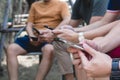 Closeup group friends hands holding modern smartphone chatting in the park. Royalty Free Stock Photo