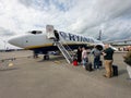 Closeup of a group of passengers boarding a commercial airplane in the UK