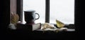 Coffee mug and book on windowsill