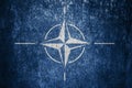 Closeup of grunge NATO flag. Dirty NATO flag on a metal surface