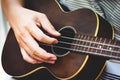 Closeup of guitarist hand playing guitar. Musical instrument concept. Outdoors and Leisure theme. Selective focus on left hand.