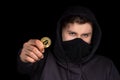Closeup hacker hold bitcoin in hand initiating cyber attack, concept cyber security, on black