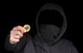 Closeup hacker hold bitcoin in hand initiating cyber attack, concept cyber security, on black