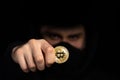 Closeup hacker hold bitcoin in hand initiating cyber attack, concept cyber security, on black