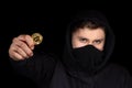 Closeup hacker hold bitcoin in hand initiating cyber attack, concept cyber security, on black