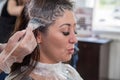 Closeup hair coloring of a brunette woman in a beauty salon. Master hairdresser at work Royalty Free Stock Photo