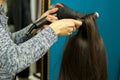 Closeup hairdresser coiffeur makes hairstyle for a woman client