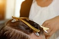 Closeup of a hairdresser cuts the wet brown hair of a client in a salon. Hairdresser cuts a woman. Side view of a hand cutting Royalty Free Stock Photo
