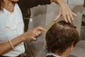 Closeup of a hairdresser cuts the wet brown hair of a client in a salon. Hairdresser cuts a woman. Side view of a hand cutting Royalty Free Stock Photo