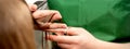 Closeup of a hairdresser cutting hair tips of a female customer in a beauty salon. Royalty Free Stock Photo