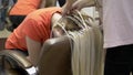 Closeup. hairdresser doing afro pigtails to a blonde girl