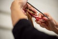 Closeup of female hands holding hairdresser scissors and cutting long blond hair. Hair cutting concept Royalty Free Stock Photo