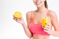 Closeup of half orange and juice holded by fitness woman Royalty Free Stock Photo