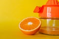 Closeup of a half orange with a squeezer isolated on a yellow background Royalty Free Stock Photo