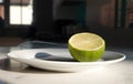 Closeup of a half slice of lime on a ceramic plate in the kitchen