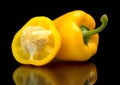Closeup halved yellow bell peppers isolated on black