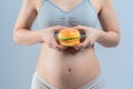 Closeup of hamberger junk food and pregnant woman is not good healthy for mother and infant