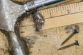 Closeup of hammer, yard stick and rusty screws on workbench