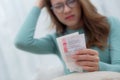 Closeup hand asian woman sitting on sofa worried with bills about financial and stress at home. Royalty Free Stock Photo