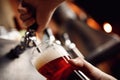 Closeup hand barman dark craft cold beer pour in glass from crane in pub Royalty Free Stock Photo